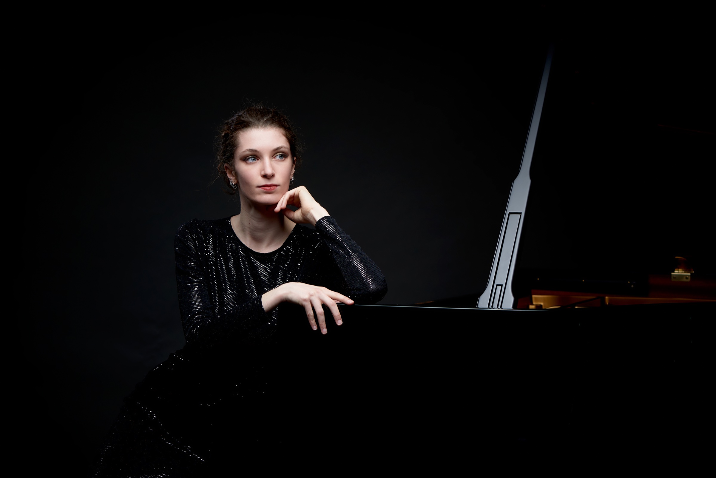 Sarah Zajtmann assise auprès d’un piano à queue